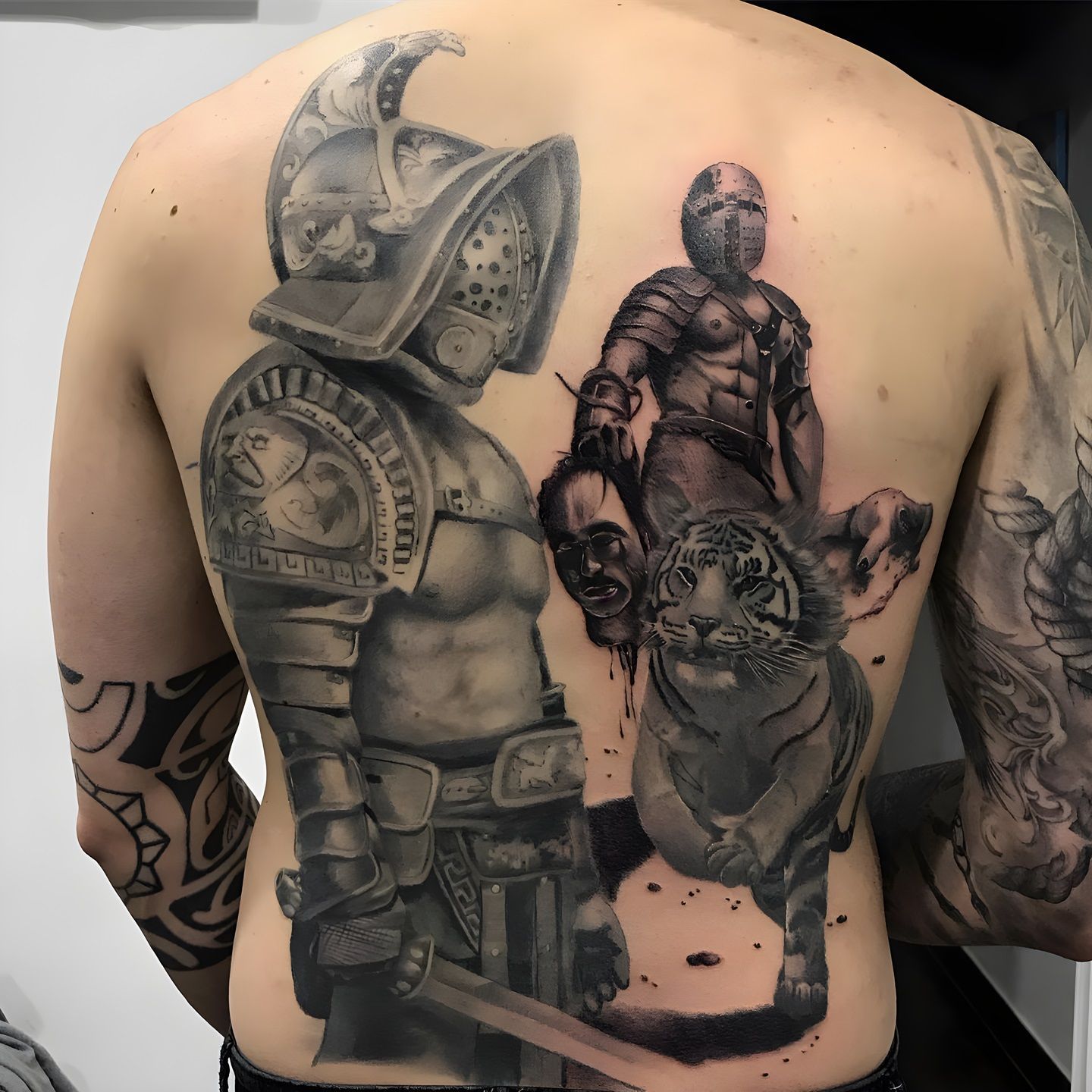 Tatuaje realista de gladiadores y tigre realizado por Aitor Murga en Ink for All Tattoo