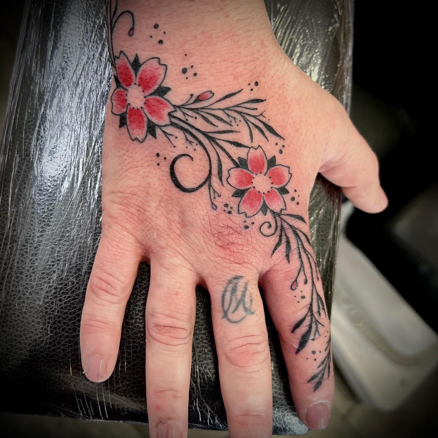 Tatuaje en color de flores el dorso de la mano realizado por Aitor Murga en Ink for All