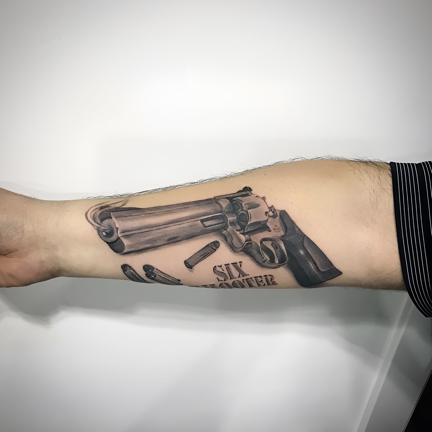 Tattoo realista de Six Shooter realizado por Aitor Murga en Ink for All