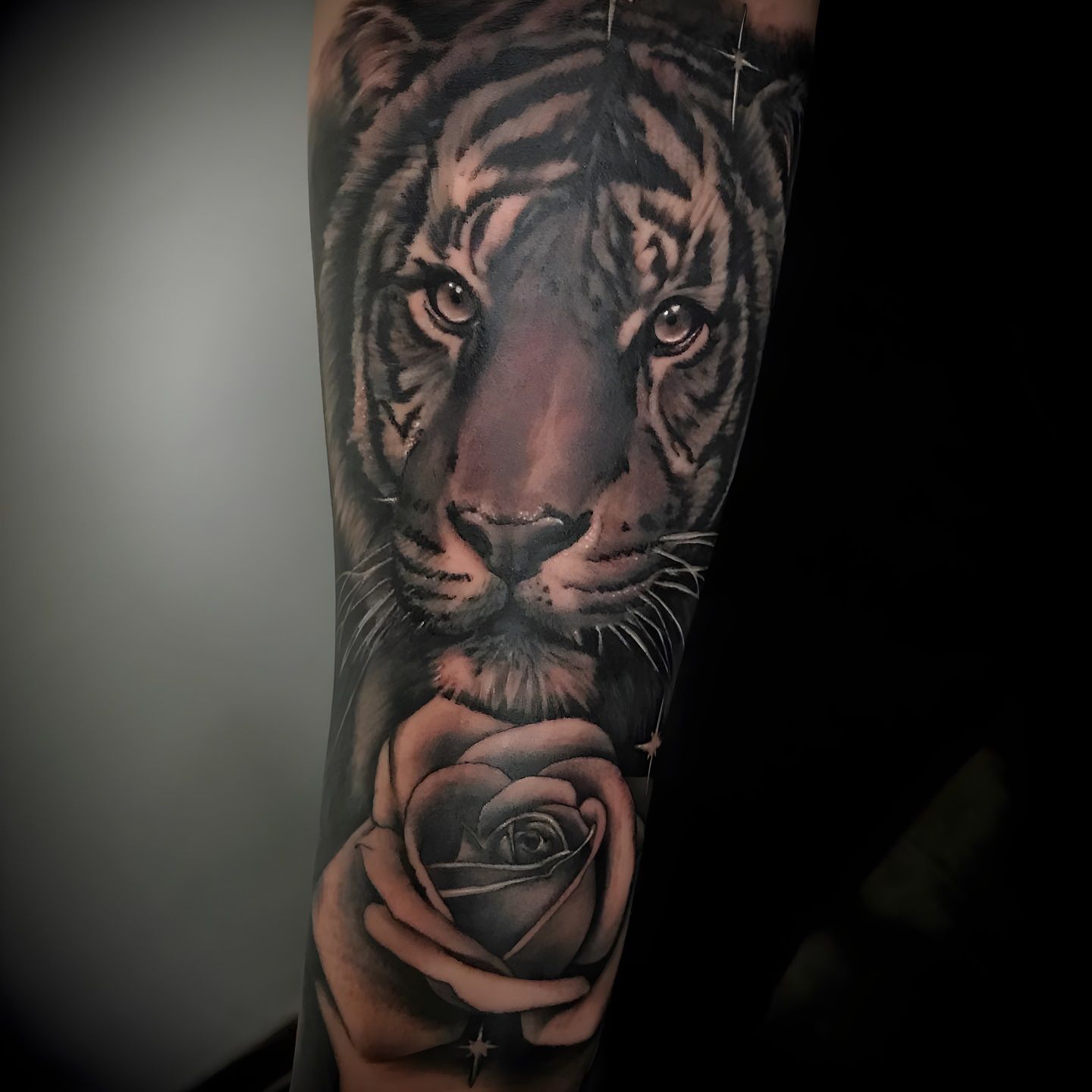 Tatuaje realista de un tigre y una rosa realizado por Aitor Murga en Ink for All