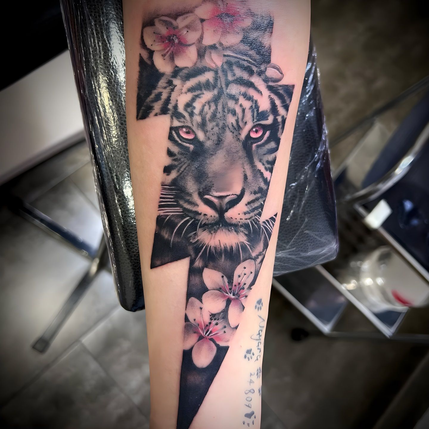 Tatuaje realista de un tigre con flores realizado por Aitor Murga en Ink for All